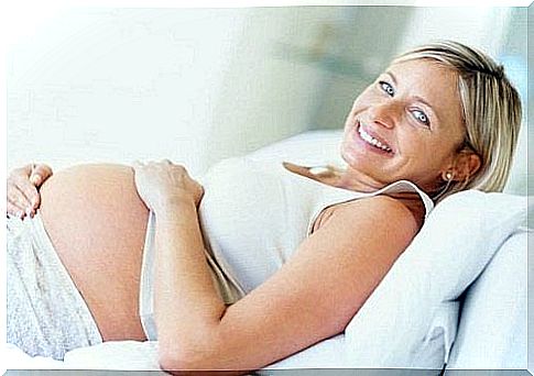 Pregnant woman caresses her belly for prenatal stimulation