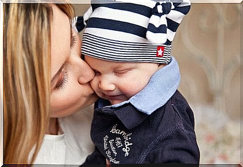 Mother kisses baby on the cheek