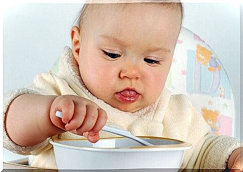 The first food - baby eats with a spoon