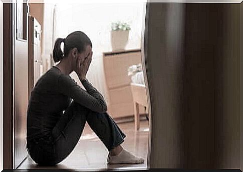 Depression - woman sitting on the floor crying